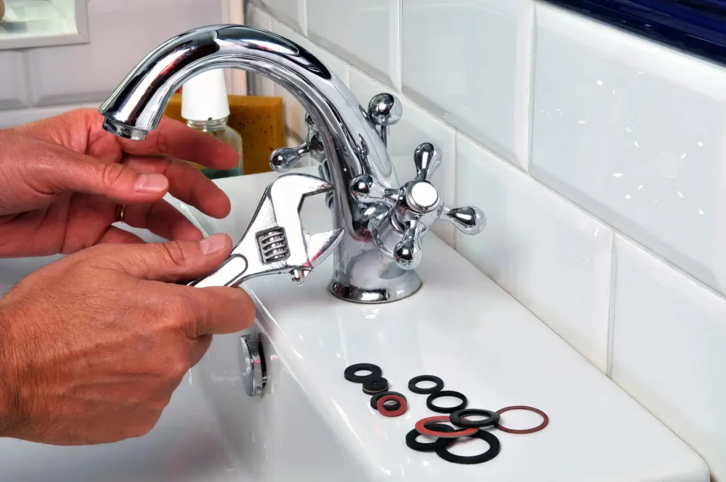 Plumber performing maintenance on a bathroom faucet in Casa Grande
