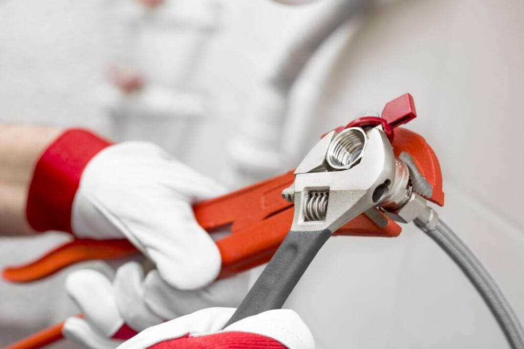 Plumber holding pipe wrenches for an emergency repair in Casa Grande