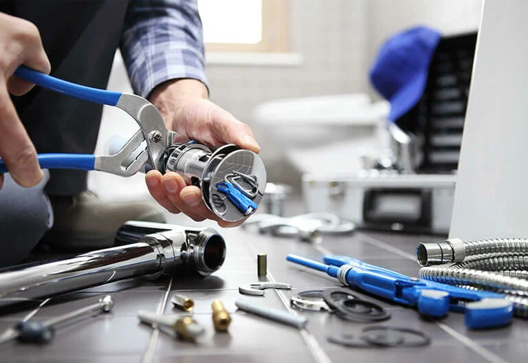 Technician repairing a plumbing fixture with professional tools in Casa Grande