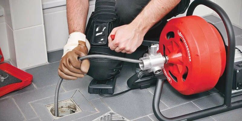 Plumber using a drain-cleaning machine in Casa Grande