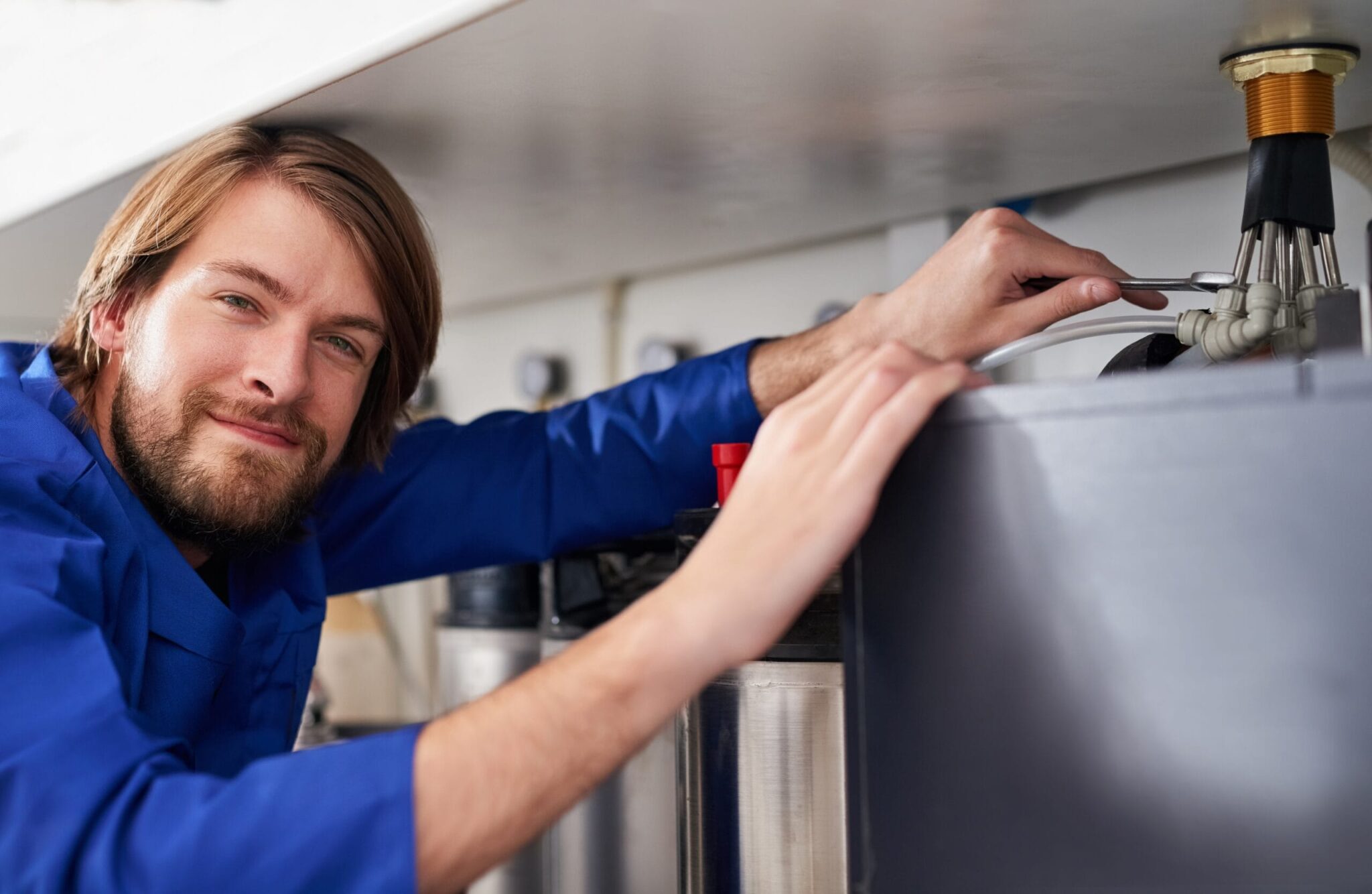 Technician servicing a residential water heater tank in Casa Grande