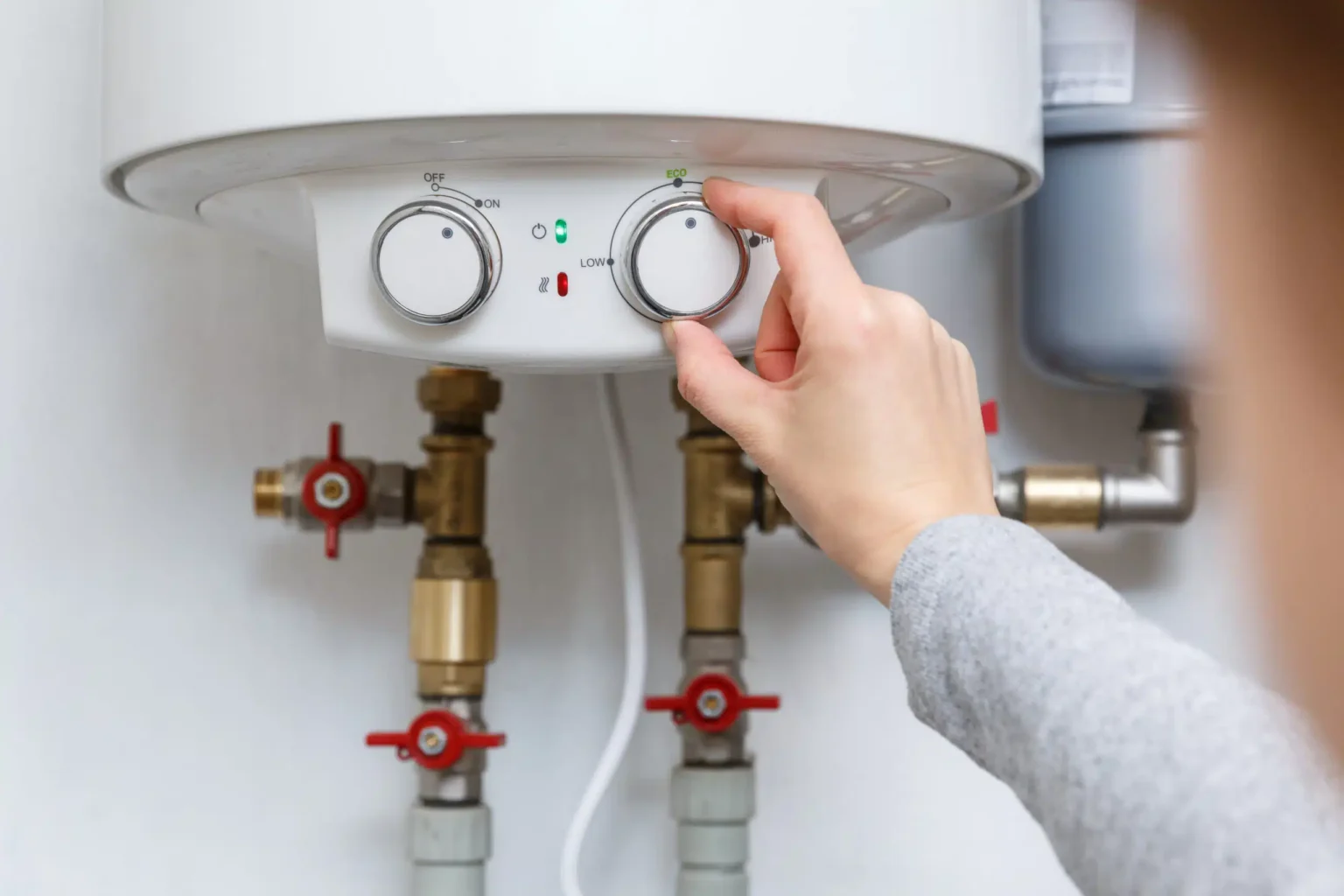 Homeowner adjusting the temperature controls on a water heater in Casa Grande