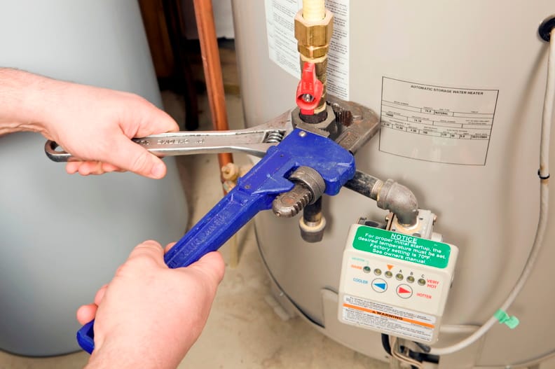 Plumber repairing a water heater valve in Casa Grande